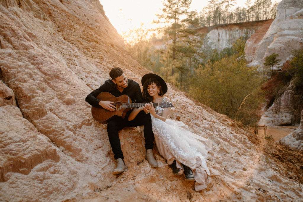 Bride and groom playing the guitar in the mountains. This elopement ideas is precious to incorporate on your wedding day.