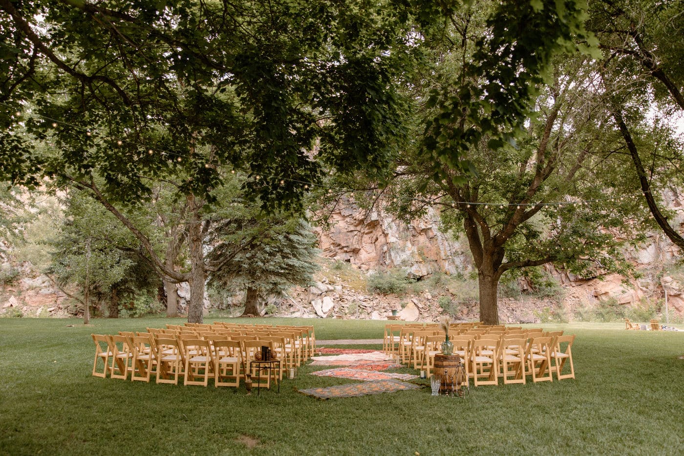River Bend Wedding Venue in Colorado set up for the ceremony with persian rugs and a gorgeous red rock backdrop. This is one of the best Colorado wedding venues.