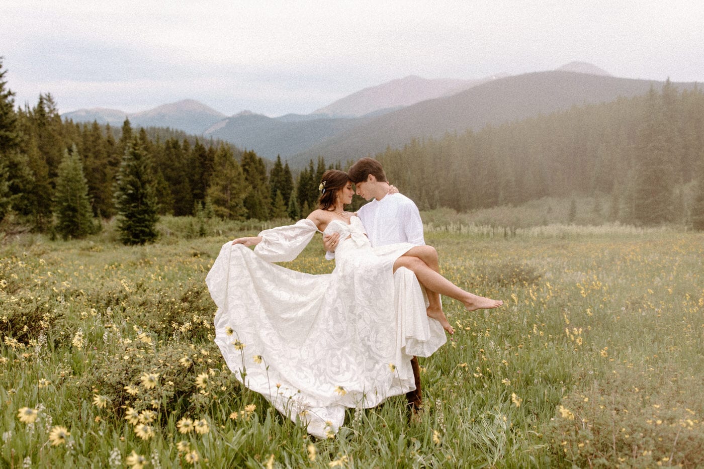 A bride and groom in a whimsical pose on their elopement day in Breckenridge, Colorado.