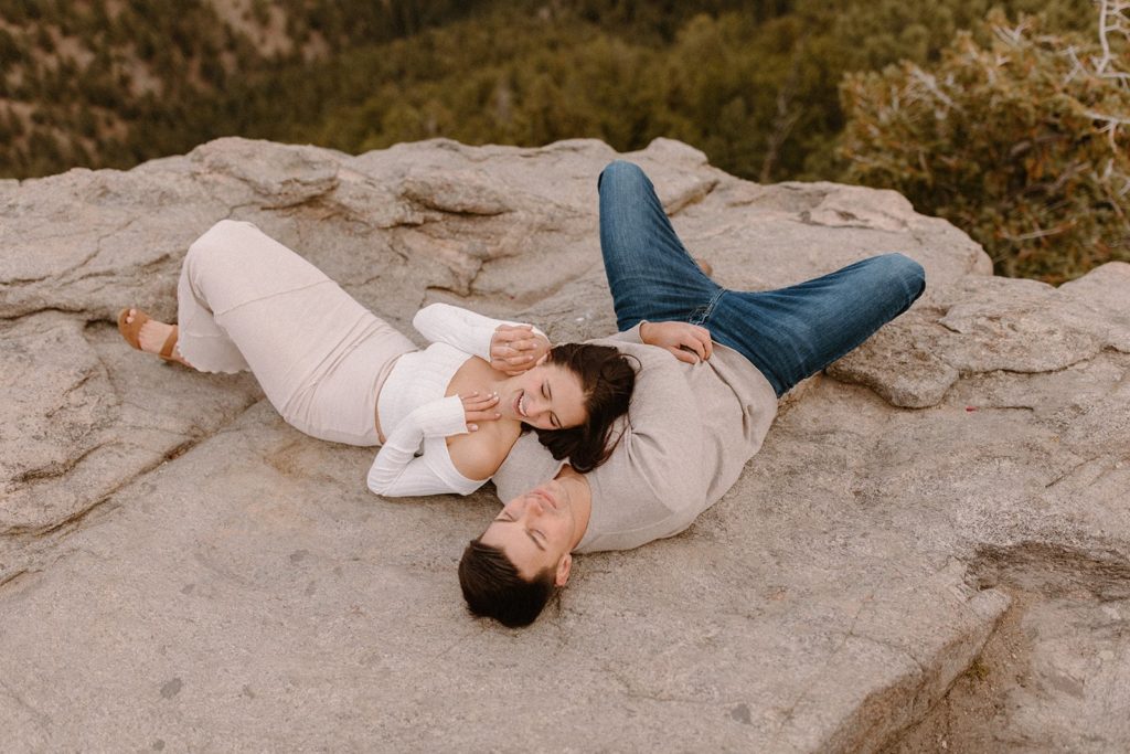 woman lying on her man at their Lost Gulch Overlook Sunrise Engagement Session