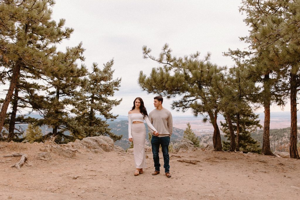 man and woman holding hands and walking at their Lost Gulch Overlook Sunrise Engagement Session