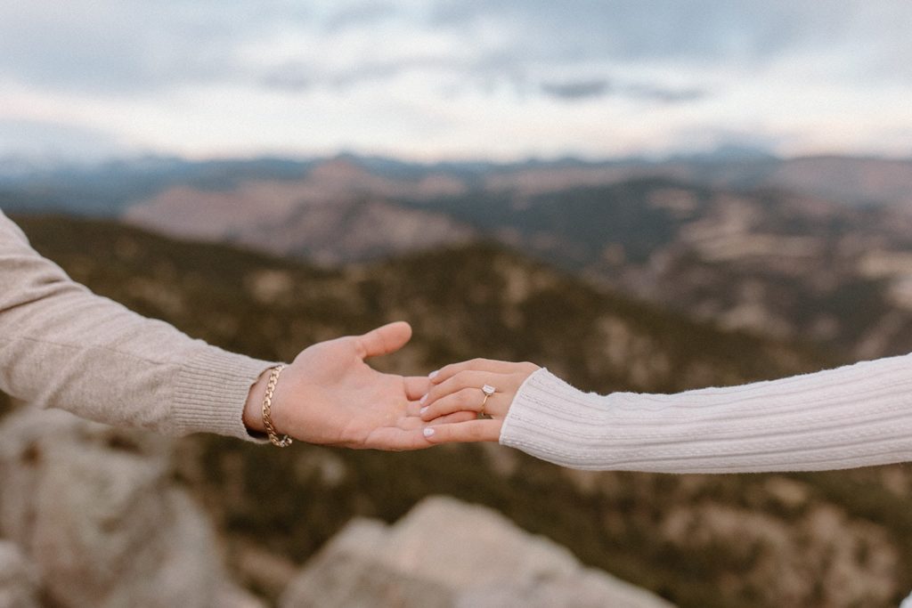 man and woman reaching for each other at their Lost Gulch Overlook Sunrise Engagement Session