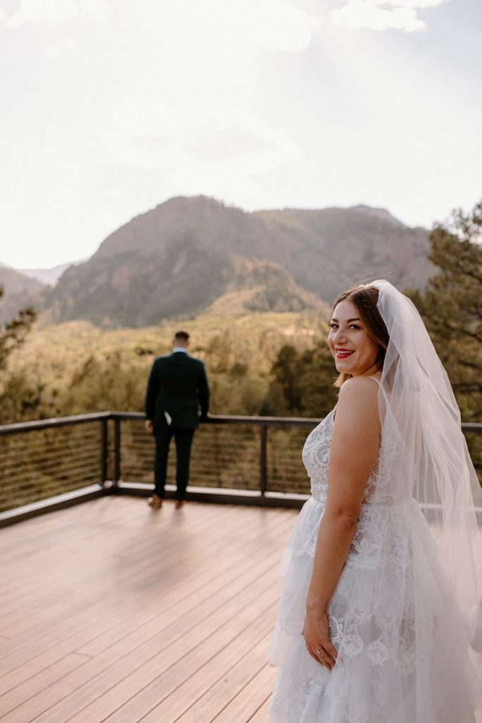 woman looking back as she is about to have a first look with her soon to be husband for their Garden of the Gods Elopement 