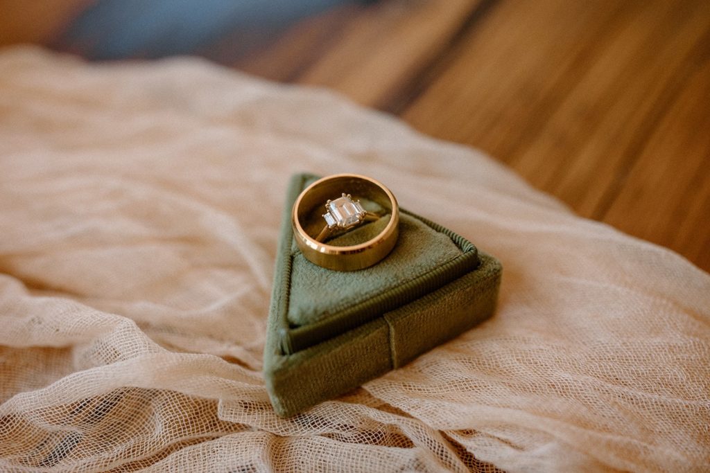 engagement and wedding rings in a green velvet triangle box for a Garden of the Gods Elopement 
