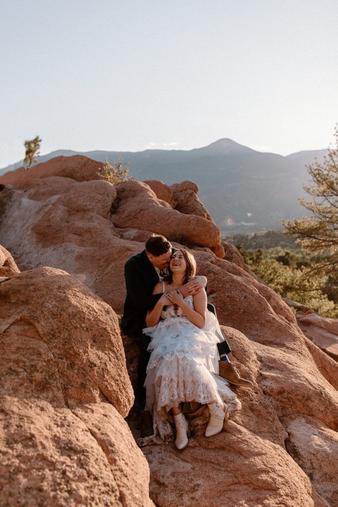 man embracing a woman from behind as they laugh on their Garden of the Gods Elopement day