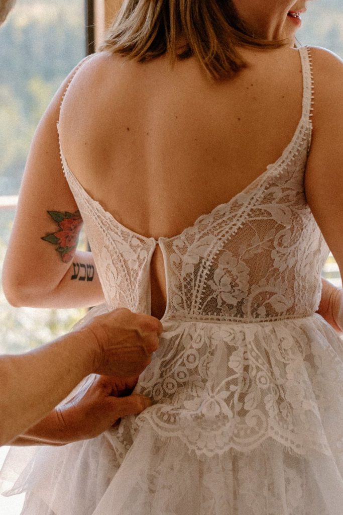woman being zipped into her wedding dress for her Garden of the Gods Elopement 