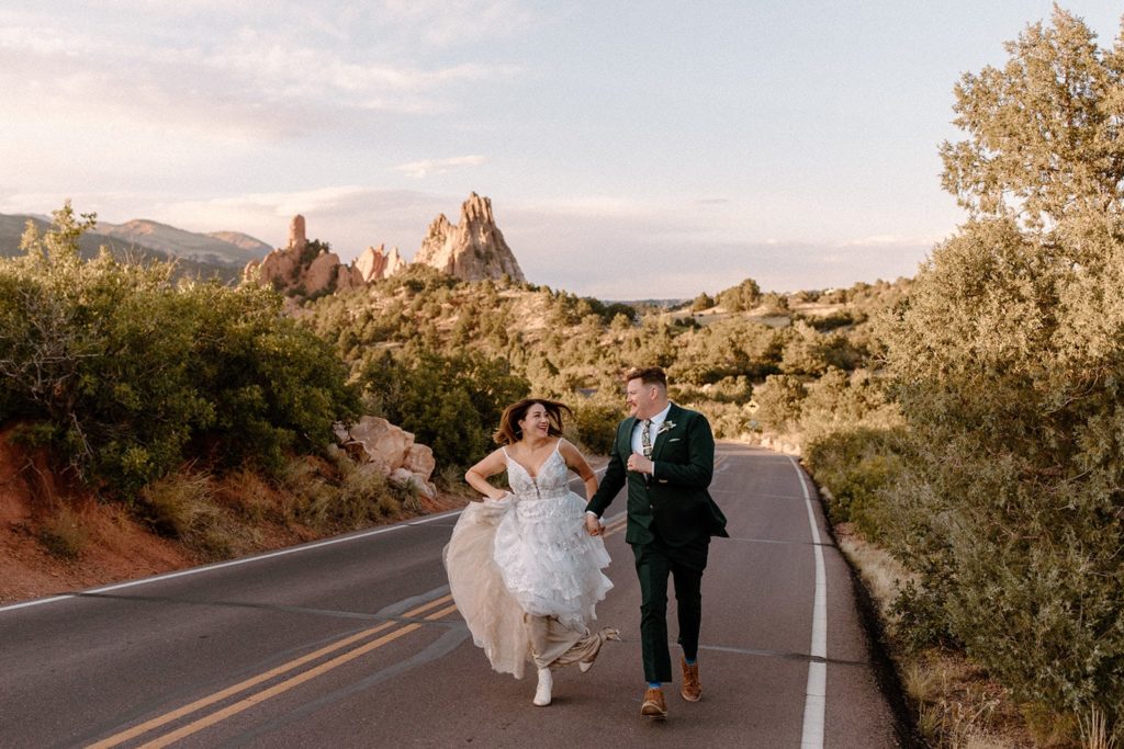 man and woman running on the road after their Garden of the Gods Elopement 