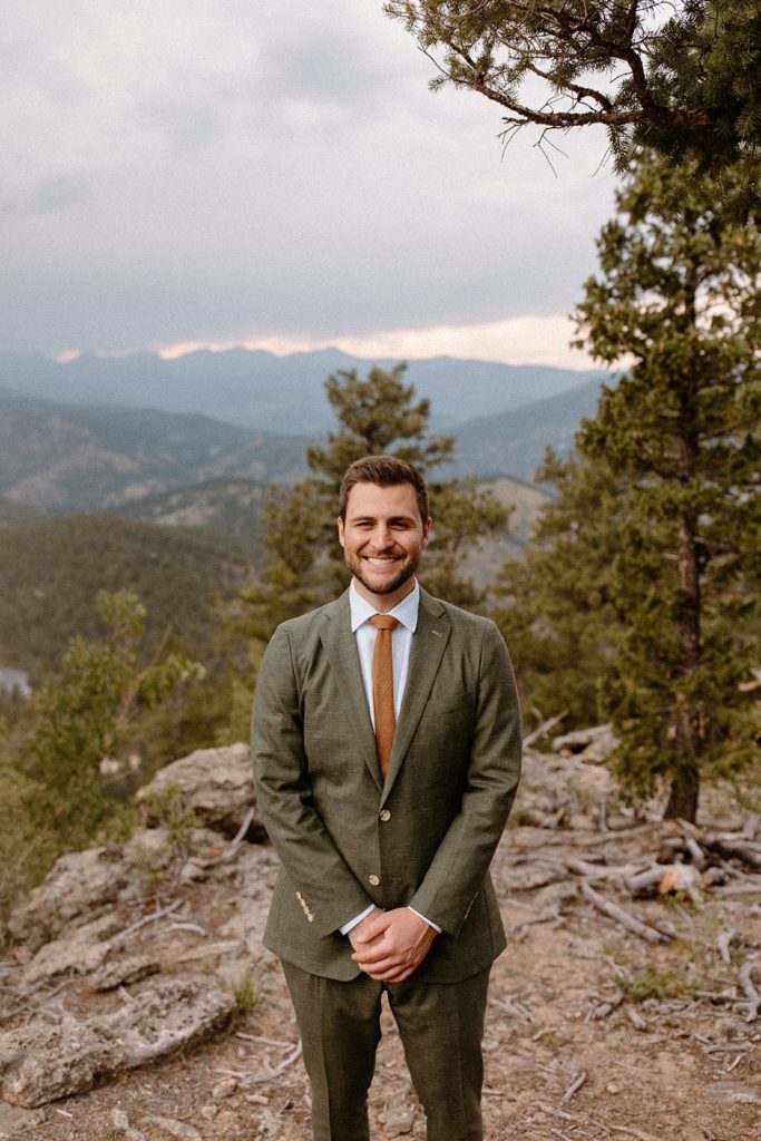 man standing in his suit on a mountain for his North Star Gatherings Wedding