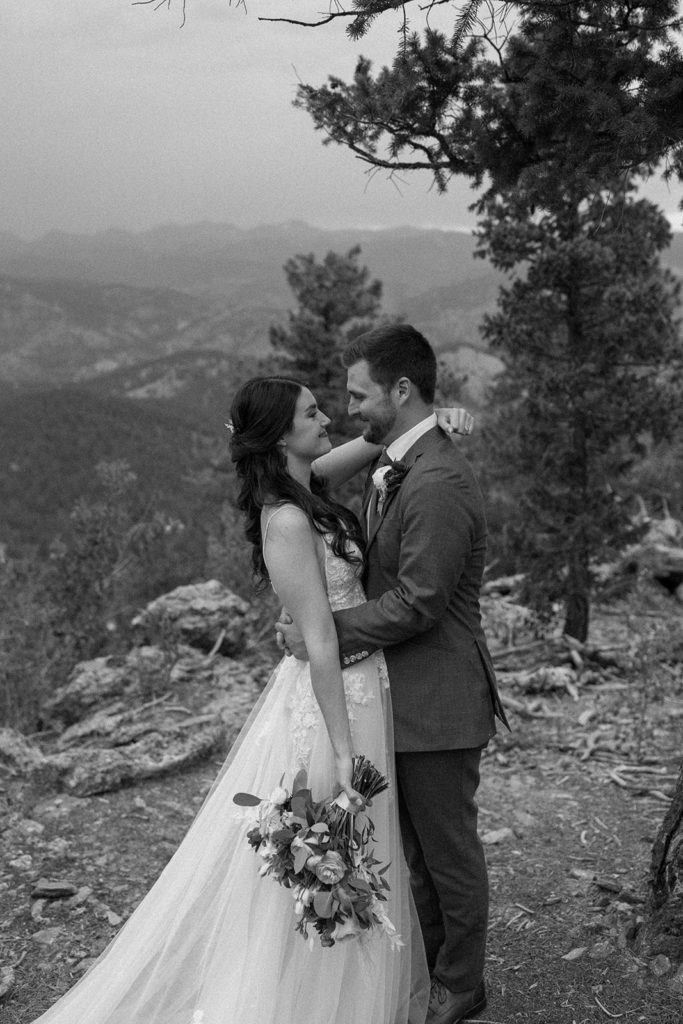 bride and groom smiling at each other on a mountain for their North Star Gatherings Wedding