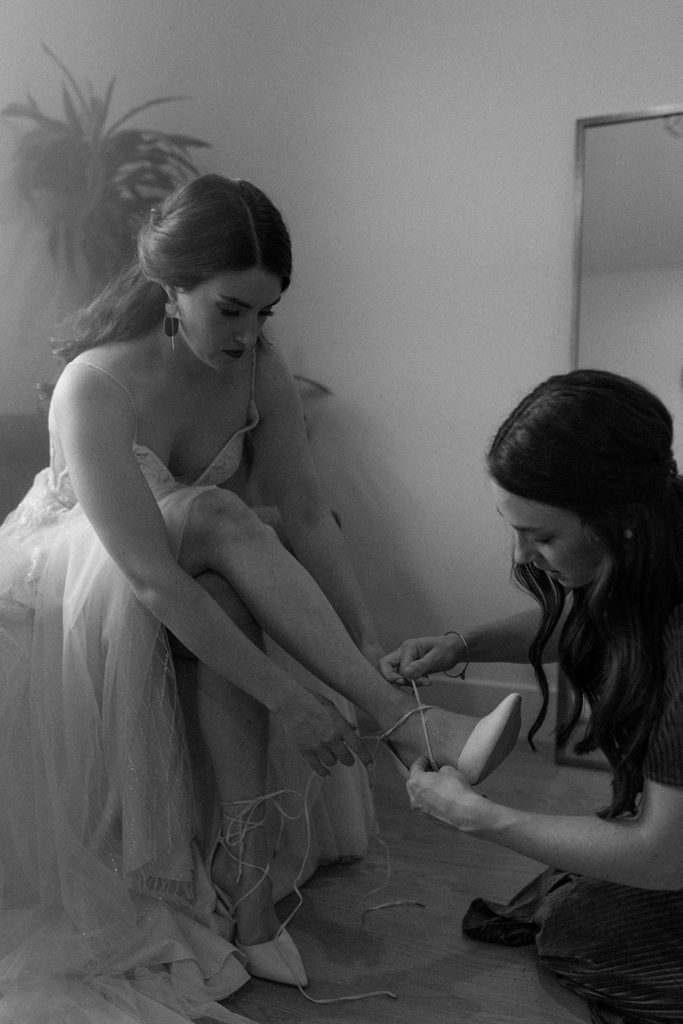 woman being helped tying her heels for her North Star Gatherings Wedding