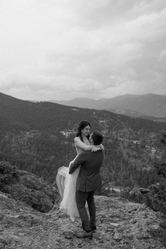 man picking up woman and gazing into her eyes on a mountain for their North Star Gatherings Wedding