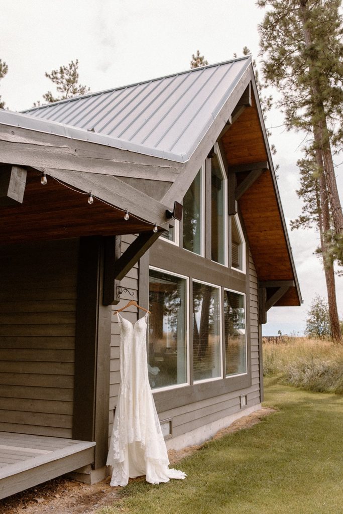 wedding dress hanging from a cabin for a Montana Elopement