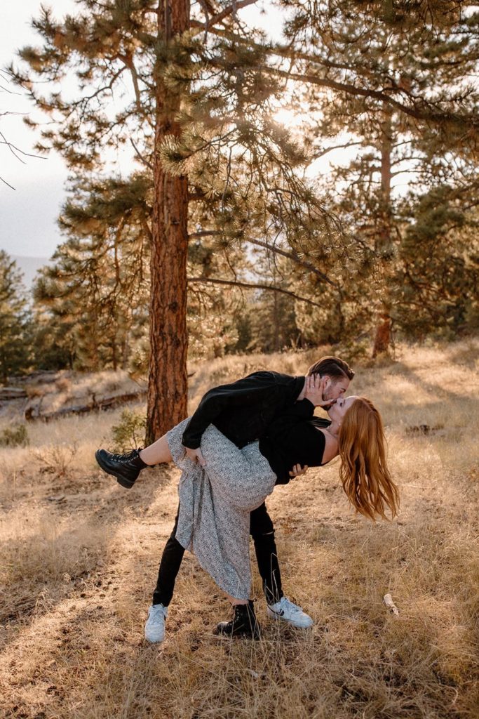 man and woman kissing while he dips her for Mountain Engagement Photos