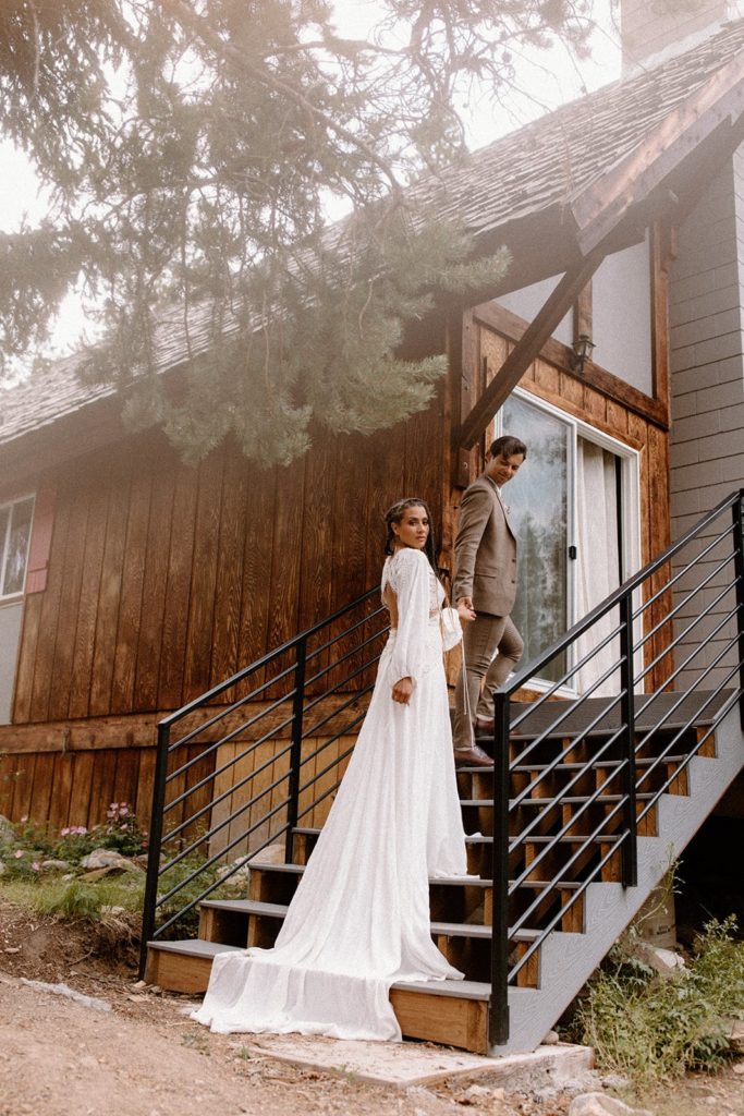 man and woman walking up the stairs to the airbnb they rented for their Colorado elopement