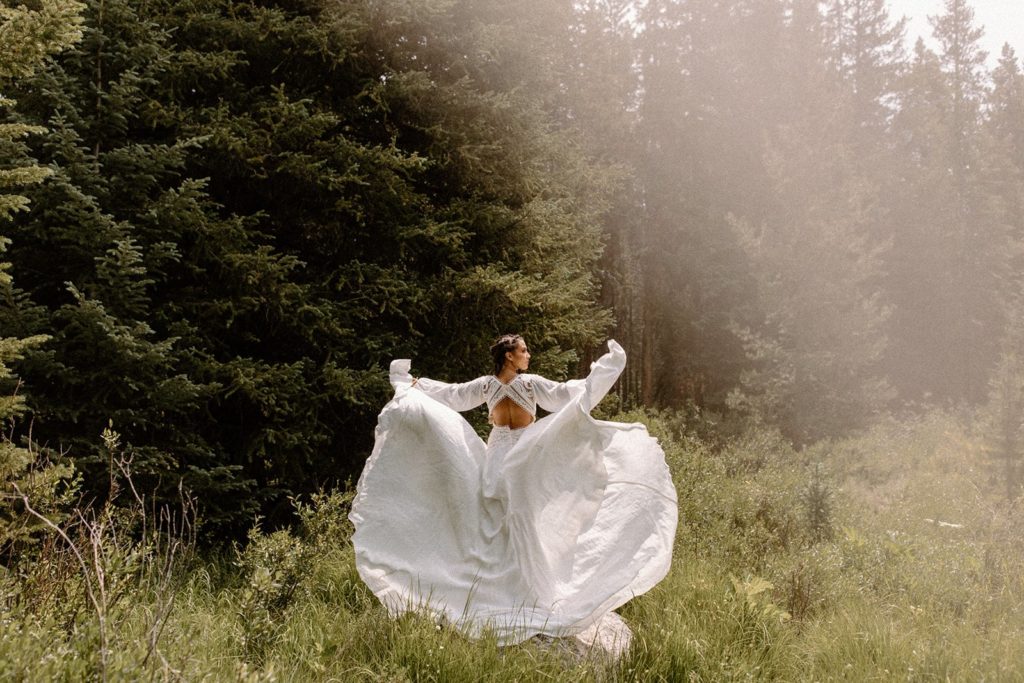woman standing with her wedding dress flowing in the wind on her Colorado elopement day