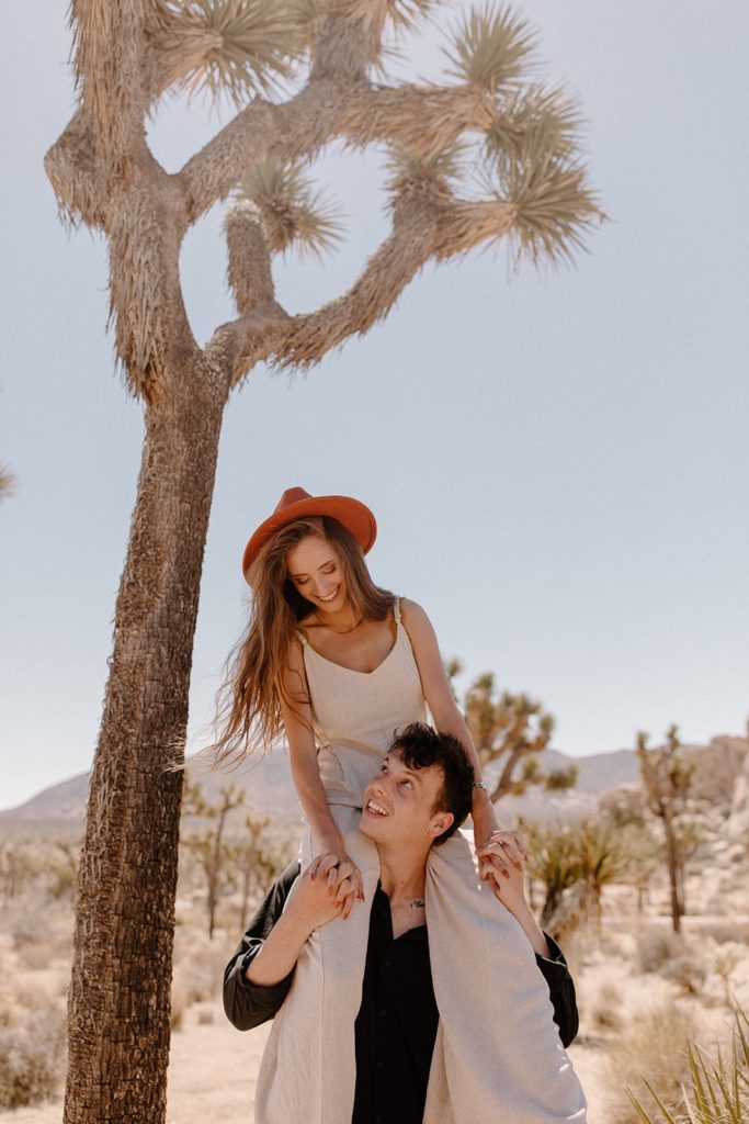 man with a woman on his shoulders in Joshua Tree National Park