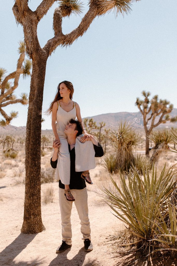 woman on man's shoulders gazing at each other in Joshua Tree National Park