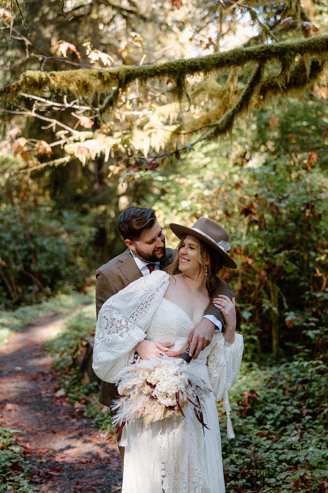 Bride and groom sharing an intimate embrace while eloping in the HoH rainforest in Washington.