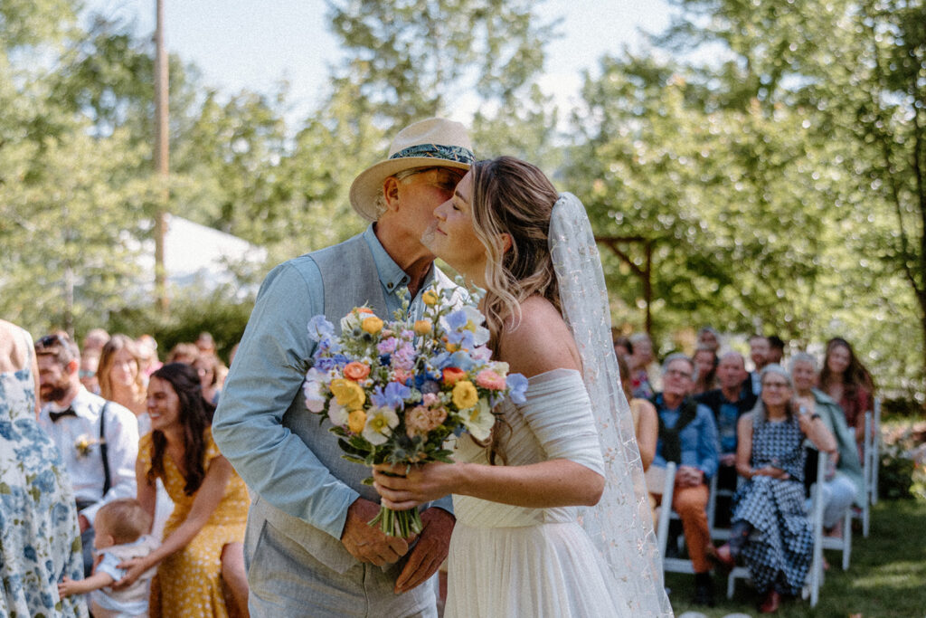 father giving his daughter away at a garden wedding