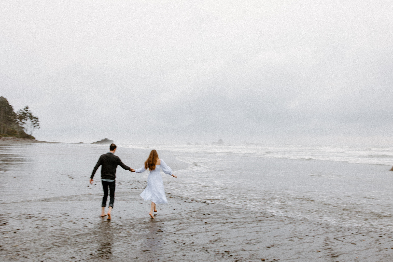 couple running during their engagement session at Ruby Beach
