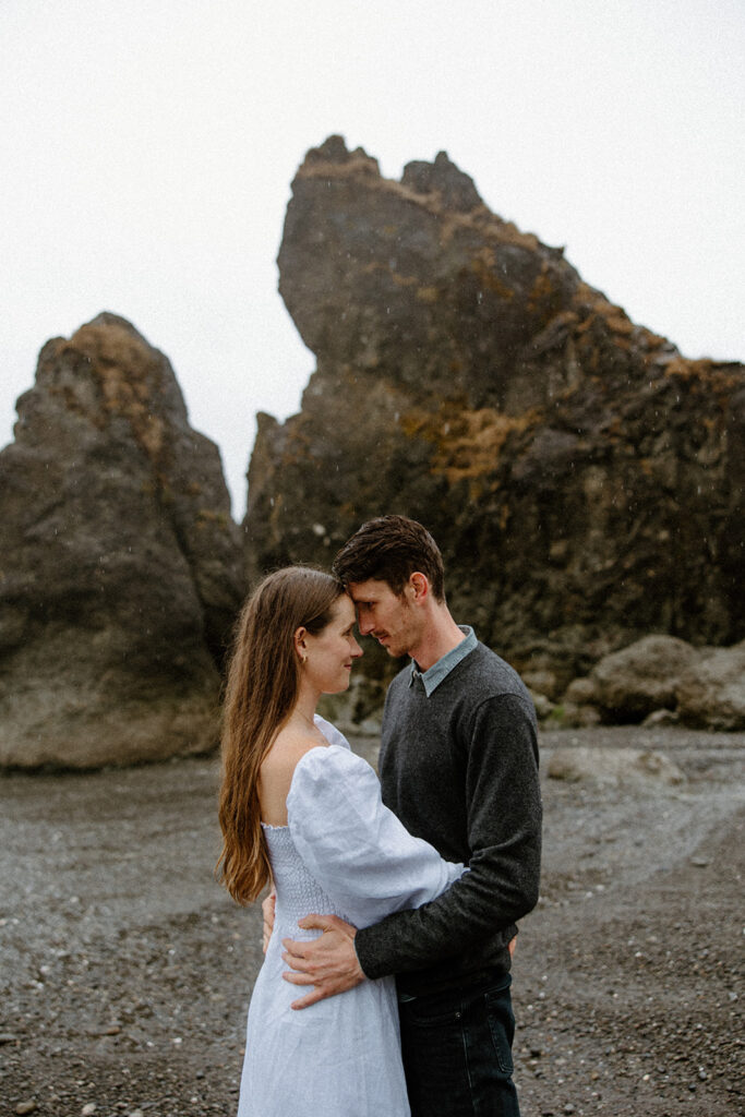 couple kissing in the rain at a ruby beach engagement session
